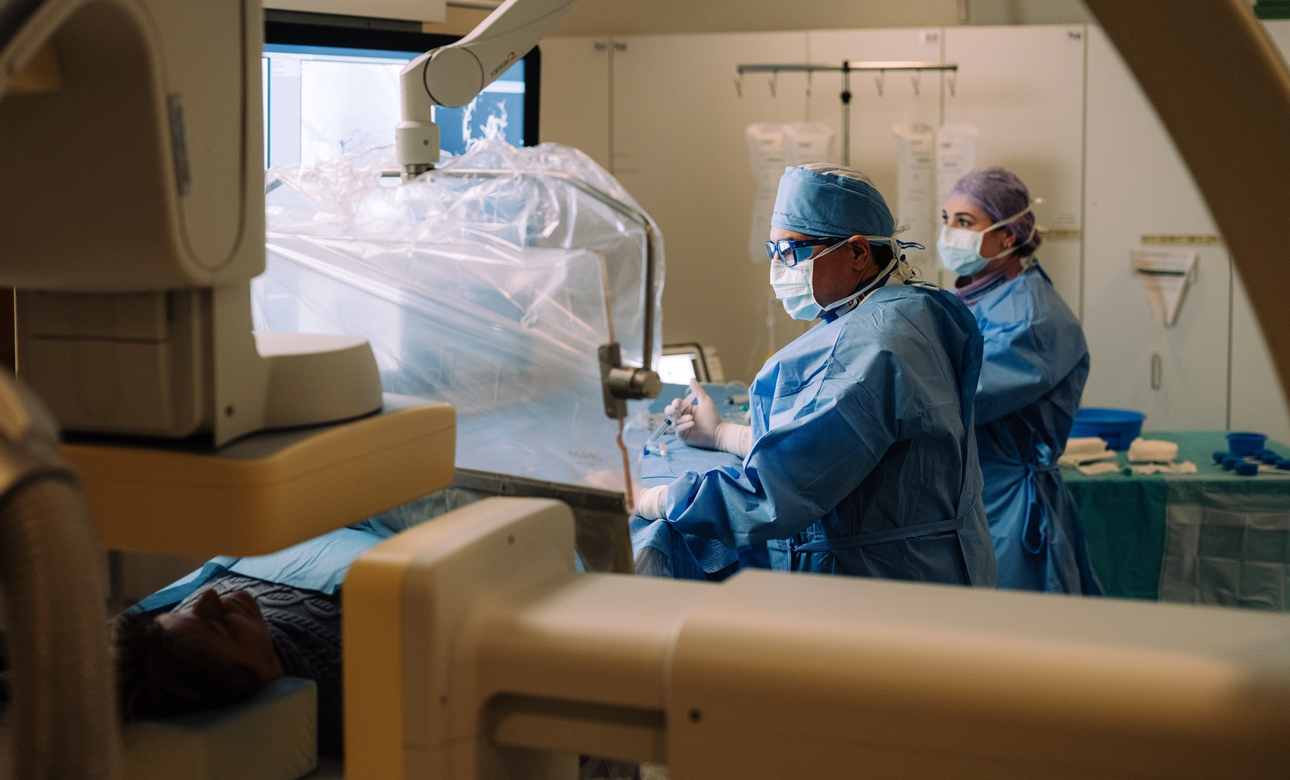 Arzt und Pflegefachfrau bei Eingriff in der Angiosuite nach einem Schlaganfall